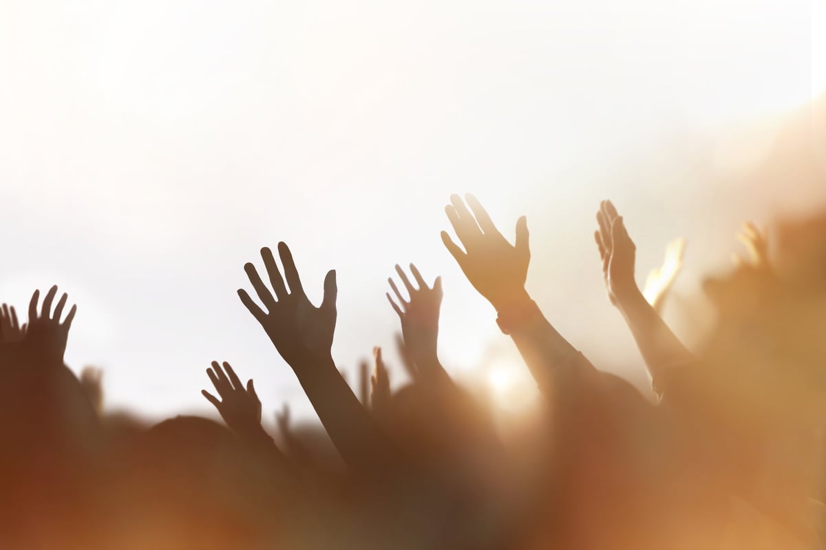 A congregation worshipping together with hands raised